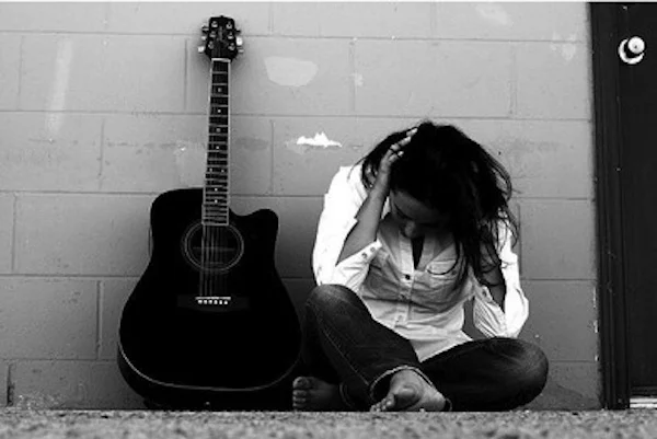 Stressed Woman next to a guitar